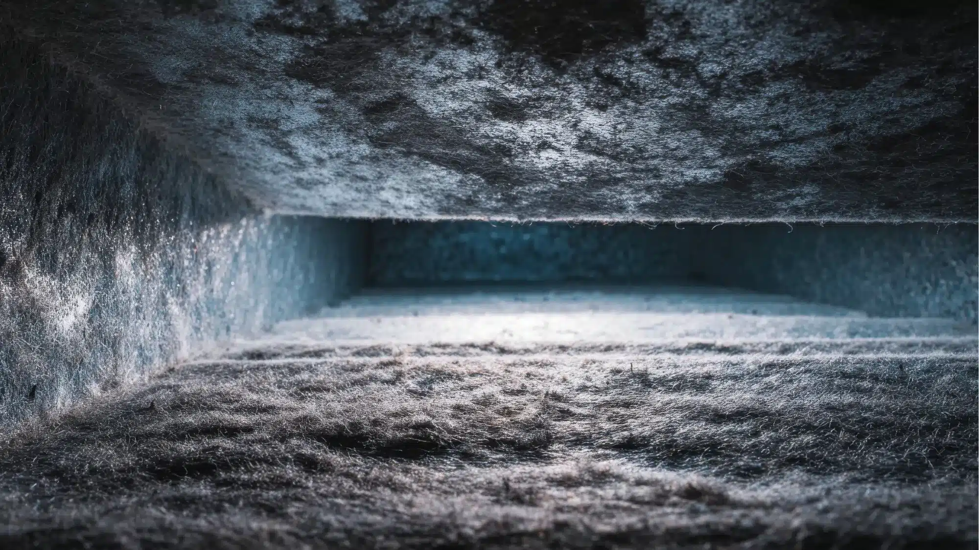 mold-inside-lined-attic-ducts-causes-warning-signs-and-solutions HVAC technician inspecting lined attic ductwork for mold growth, moisture, and material deterioration